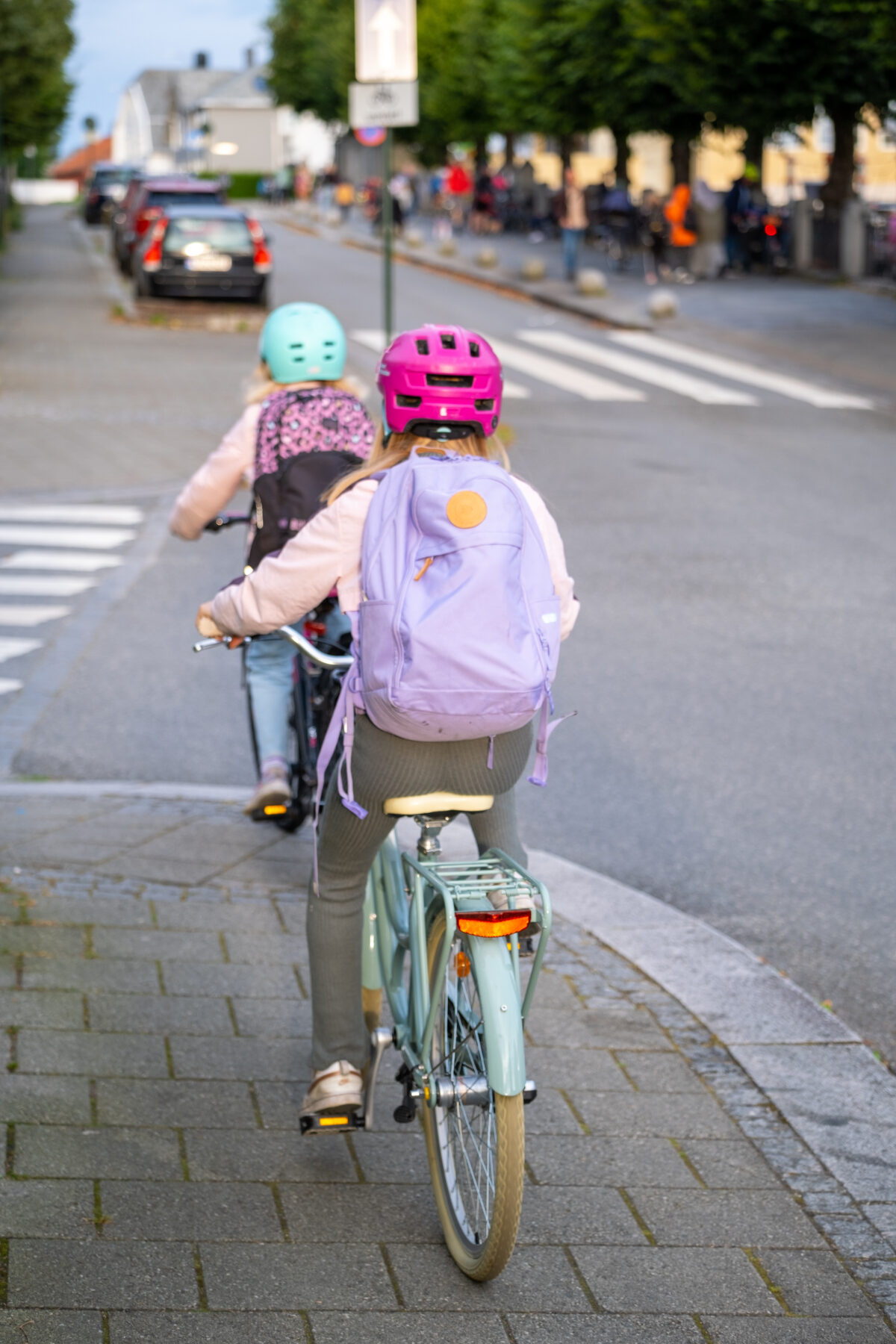 Barn som sykler med skolesekk
